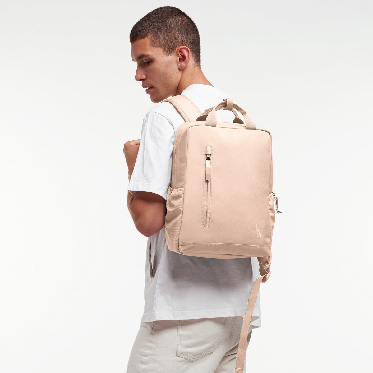 DAYPACK 2.0 MONOCHROME EDITION Rucksack in pearl (helles Puder-Rosa) von einem Mann als Rucksack auf dem Rücken getragen.