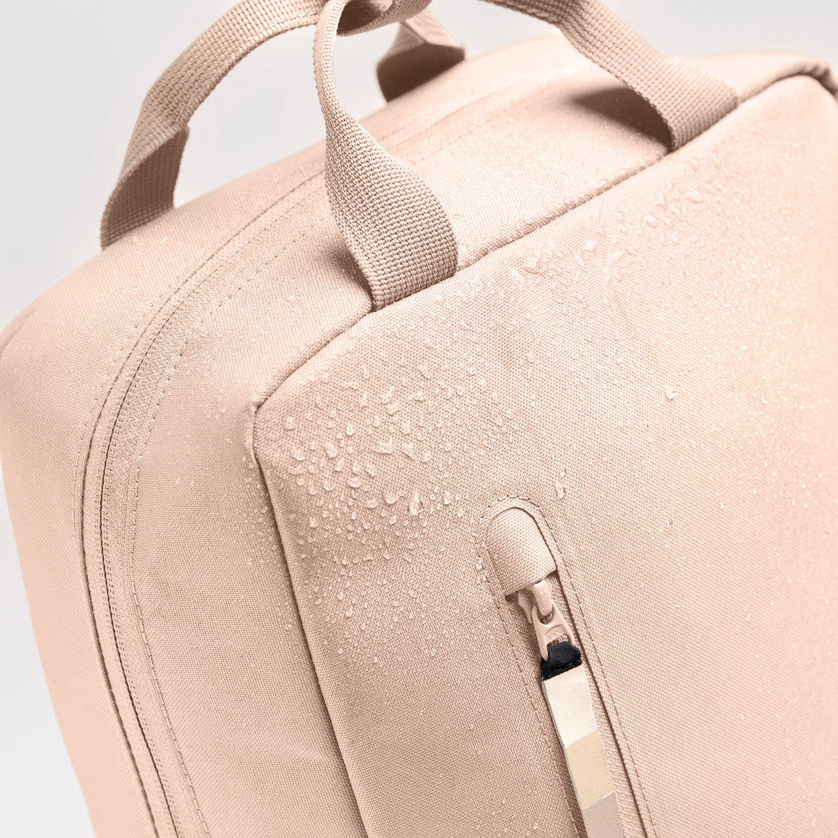 DAYPACK 2.0 Rucksack in pearl (helles Puder-Rosa) mit Wassertropfen auf dem Stoff, Detailaufnahme.