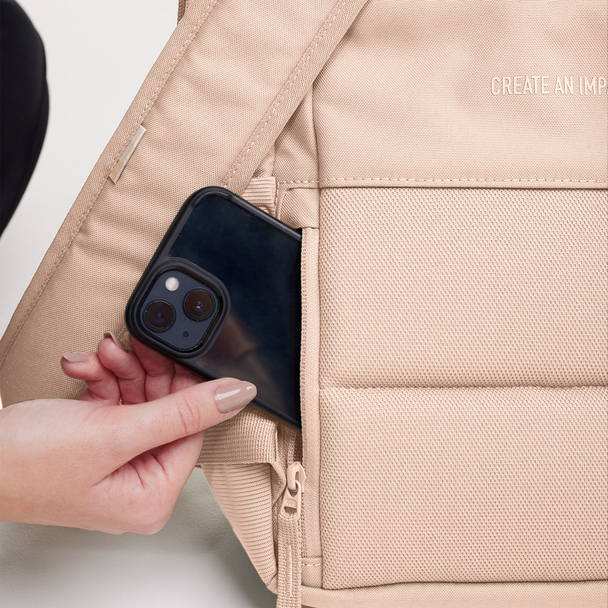 DAYPACK Rucksack in pearl (helles Puder-Rosa), Detailaufnahme einer Frau, die ein Telefon einsteckt.