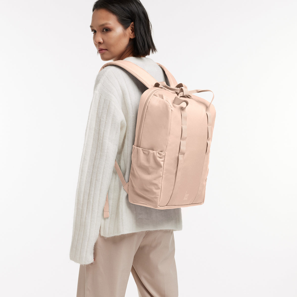 DAYPACK LOOP Rucksack in pearl (helles Puder-Rosa) von einer Frau auf dem Rücken getragen.