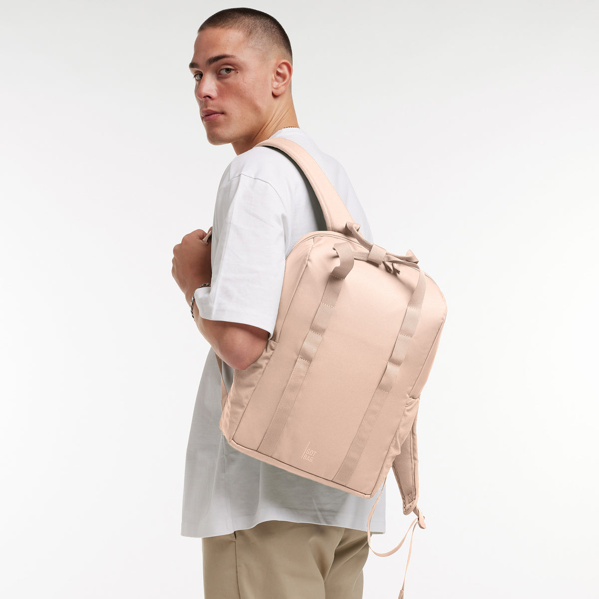 DAYPACK LOOP Rucksack in pearl (helles Puder-Rosa) von einem Mann auf dem Rücken getragen.