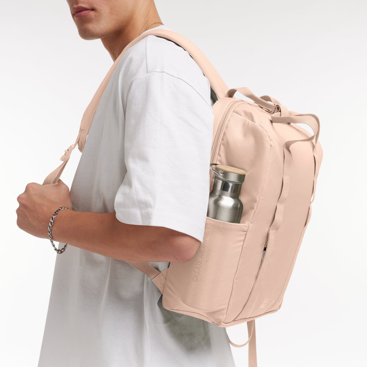 DAYPACK LOOP Monochrome Edition Rucksack in pearl (helles Puder-Rosa) von einem Mann als Rucksack auf dem Rücken getragen.