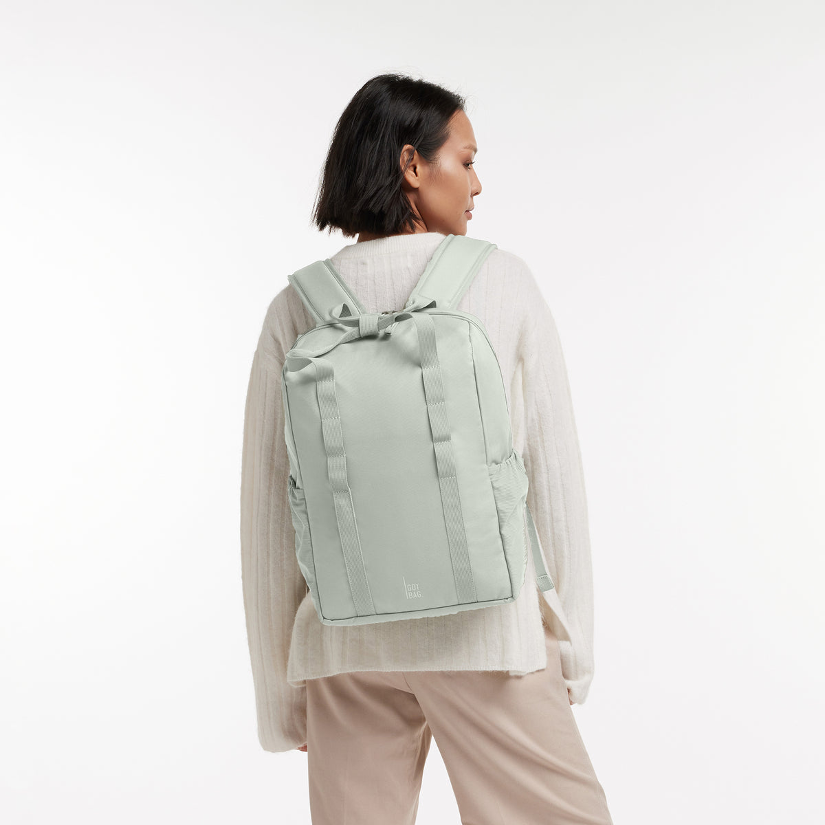 DAYPACK LOOP Rucksack in eel (sehr helles Grün/Mint) von einer Frau auf dem Rücken getragen.