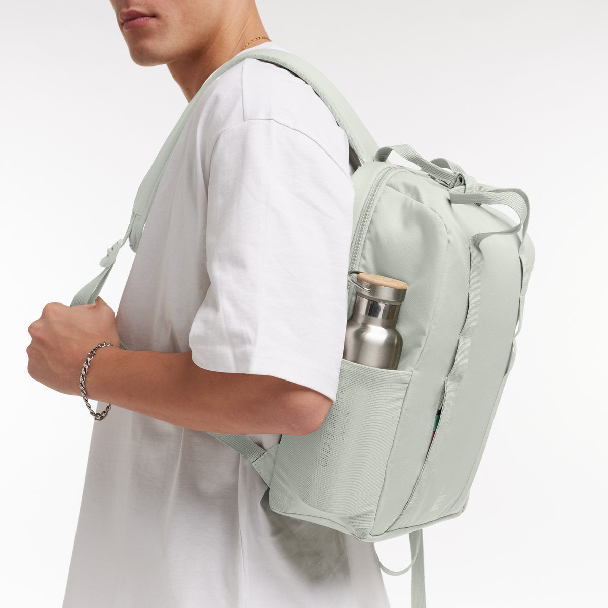 DAYPACK LOOP Rucksack in eel (sehr helles Grün/Mint) von einem Mann auf dem Rücken getragen.
