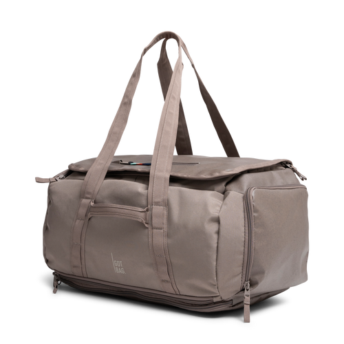 DUFFLE PACK Tasche in oyster (klassisches Taupe-Braun) in diagonaler Ansicht.