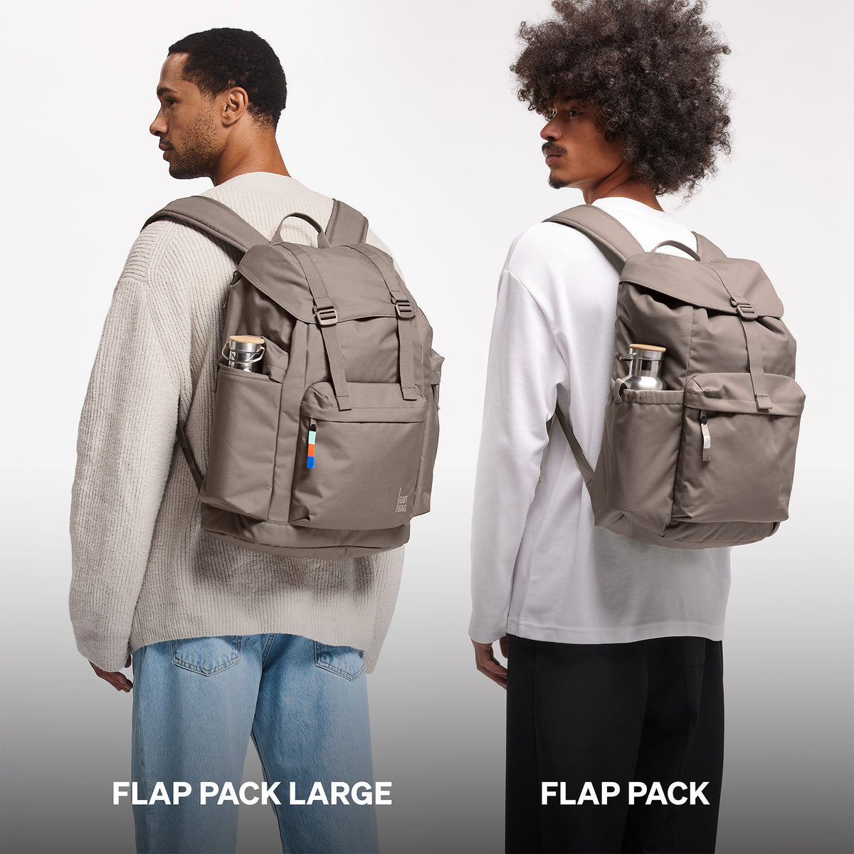 FLAP PACK LARGE Rucksack in oyster (klassisches Taupe-Braun) getragen von zwei Männern beim Größenvergleich.
