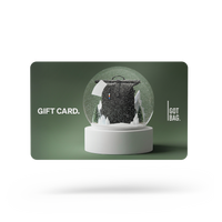 GIFT CARDS accessori: Una carta regalo verde scuro con un design a palla di neve che mostra uno zaino nella neve.
