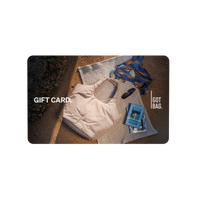 Accessori GIFT CARDS con motivo spiaggia: borsa chiara, occhiali da sole e libro su un asciugamano nella sabbia.