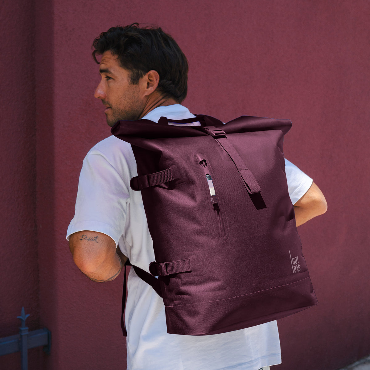 ROLLTOP Rucksack in ocean blue (Marineblau) von einem Mann als Rucksack auf dem Rücken getragen.
