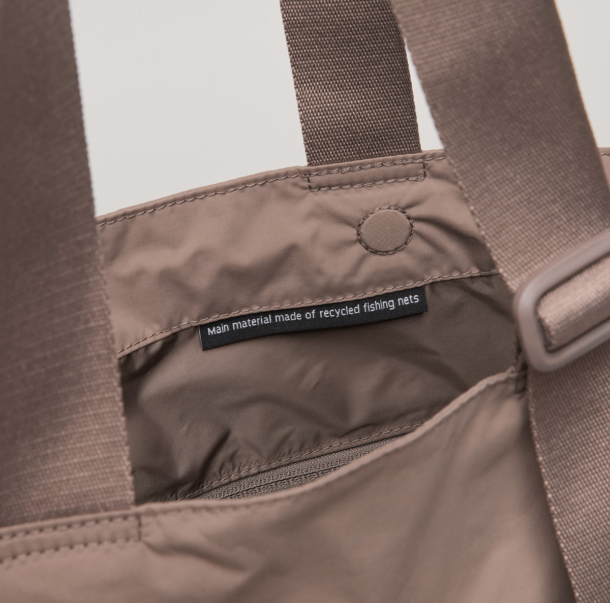 MELLOW TOTE BAG Tasche in oyster (klassisches Taupe-Braun), Detailaufnahme der Innenansicht mit Etikett.
