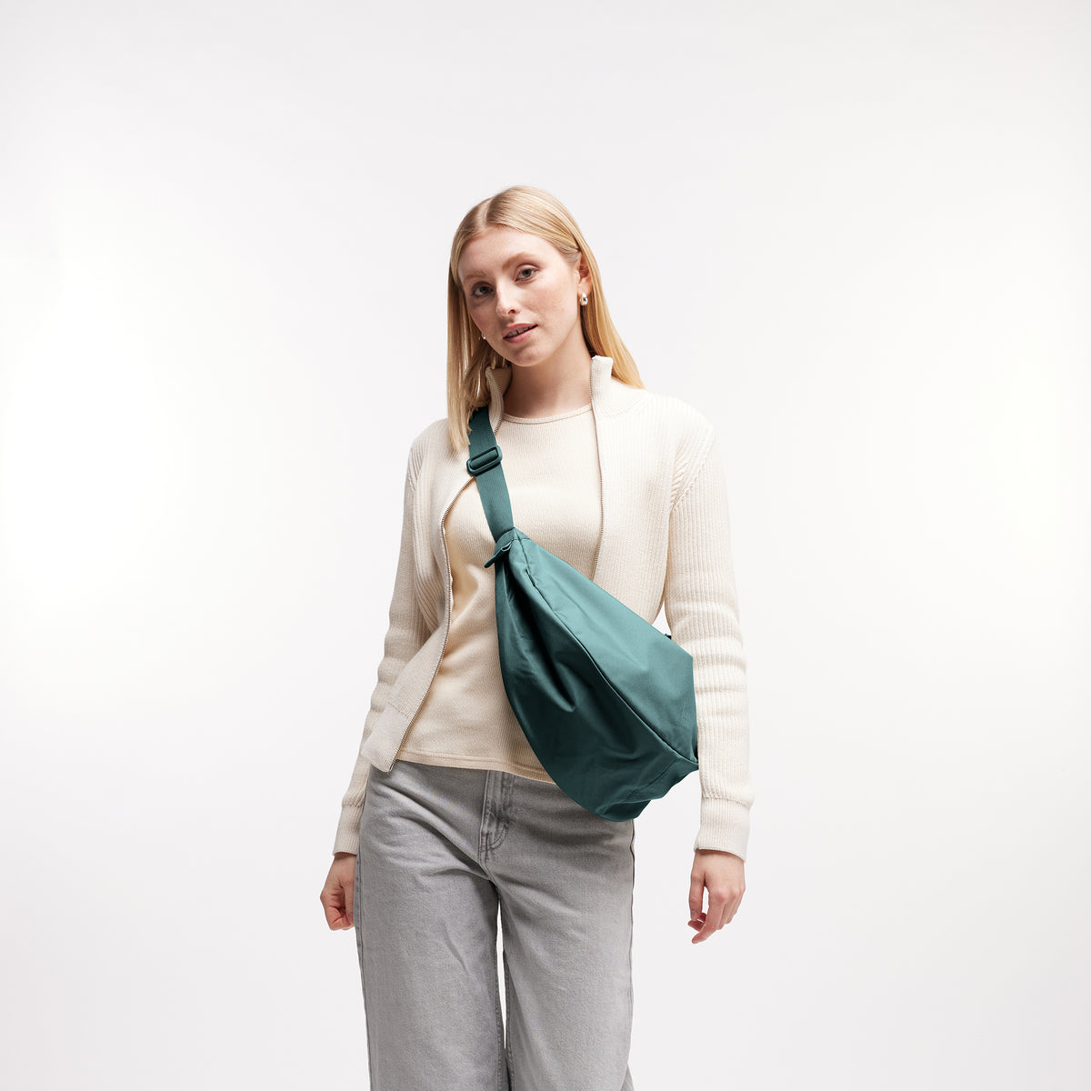MOON BAG LARGE Tasche in sea teal (kühles Türkisgrün) von einer Frau crossbody getragen.