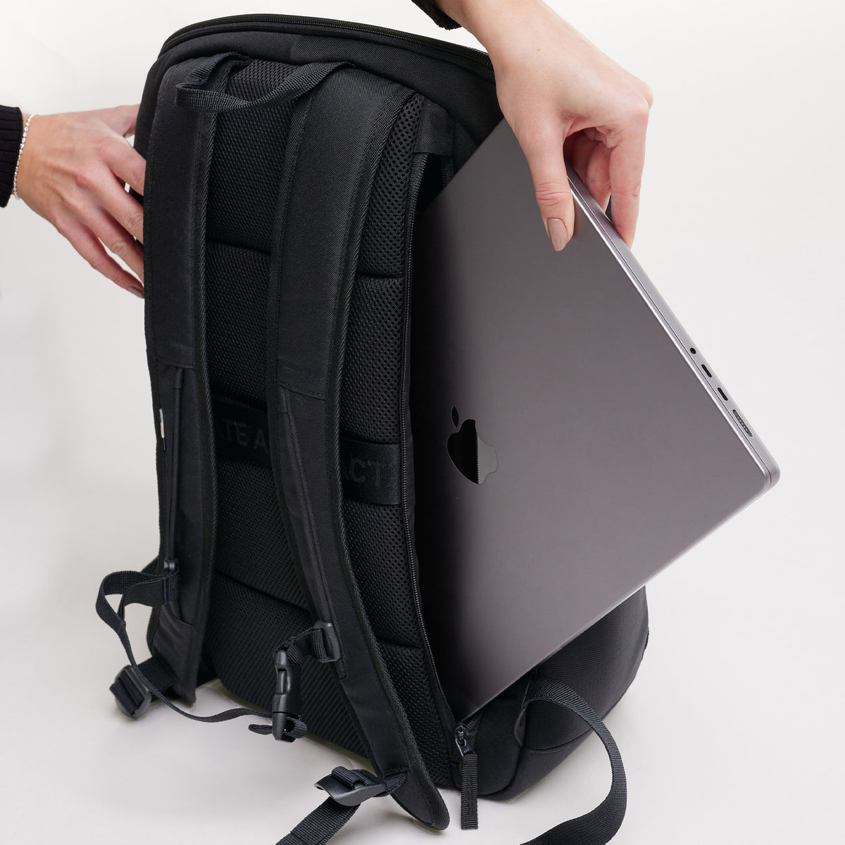 PRO PACK Rucksack in black (Schwarz), in dessen Rückenfach ein Notebook eingesetzt wird.
