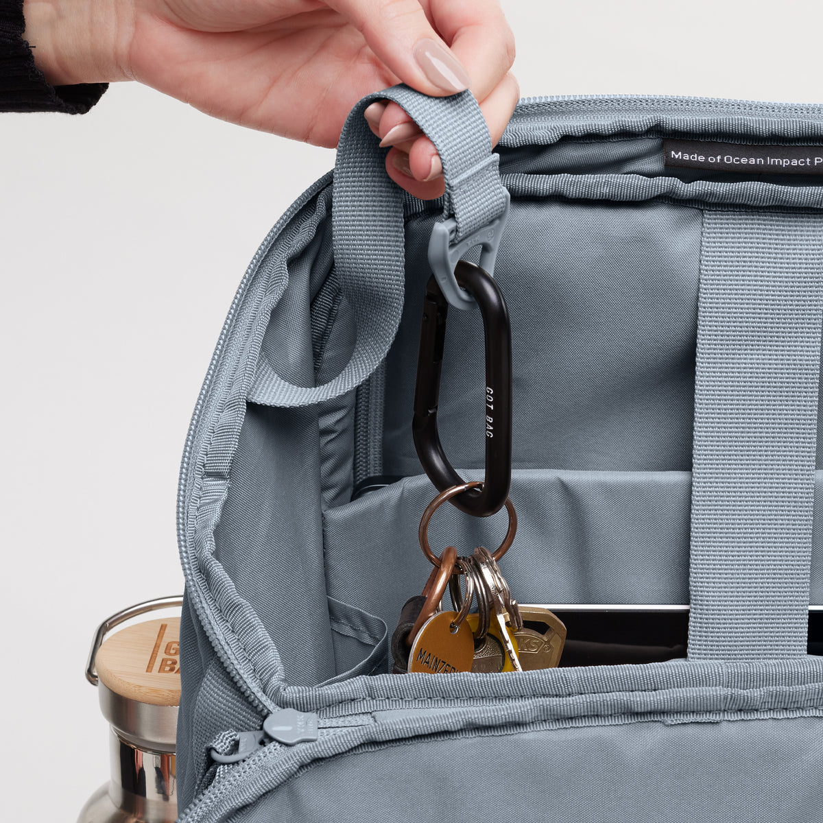 PRO PACK Tasche in marlin (grau-blau) als Detailaufnahme des Inneren; eine Frau hält den Gurt.