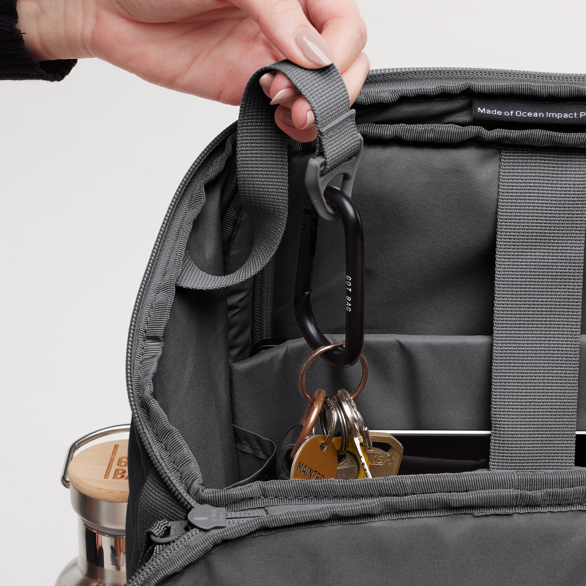 PRO PACK Rucksack in shark (Dunkelgrau), von einer Hand geöffnet, zeigt Schlüssel an einem Karabiner.