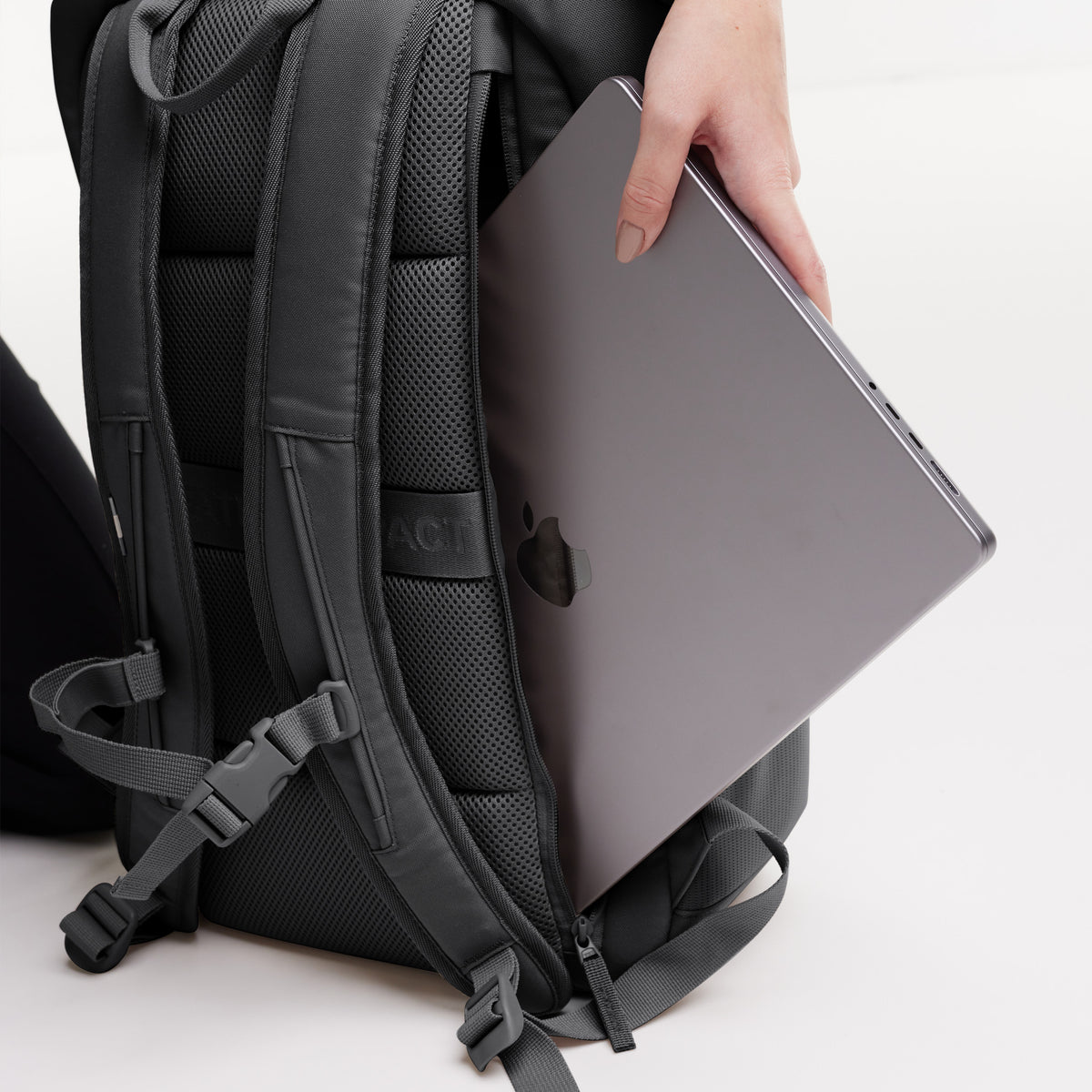 Detailaufnahme eines PRO PACK Rucksacks in shark (Dunkelgrau) beim Einstecken eines Laptops.
