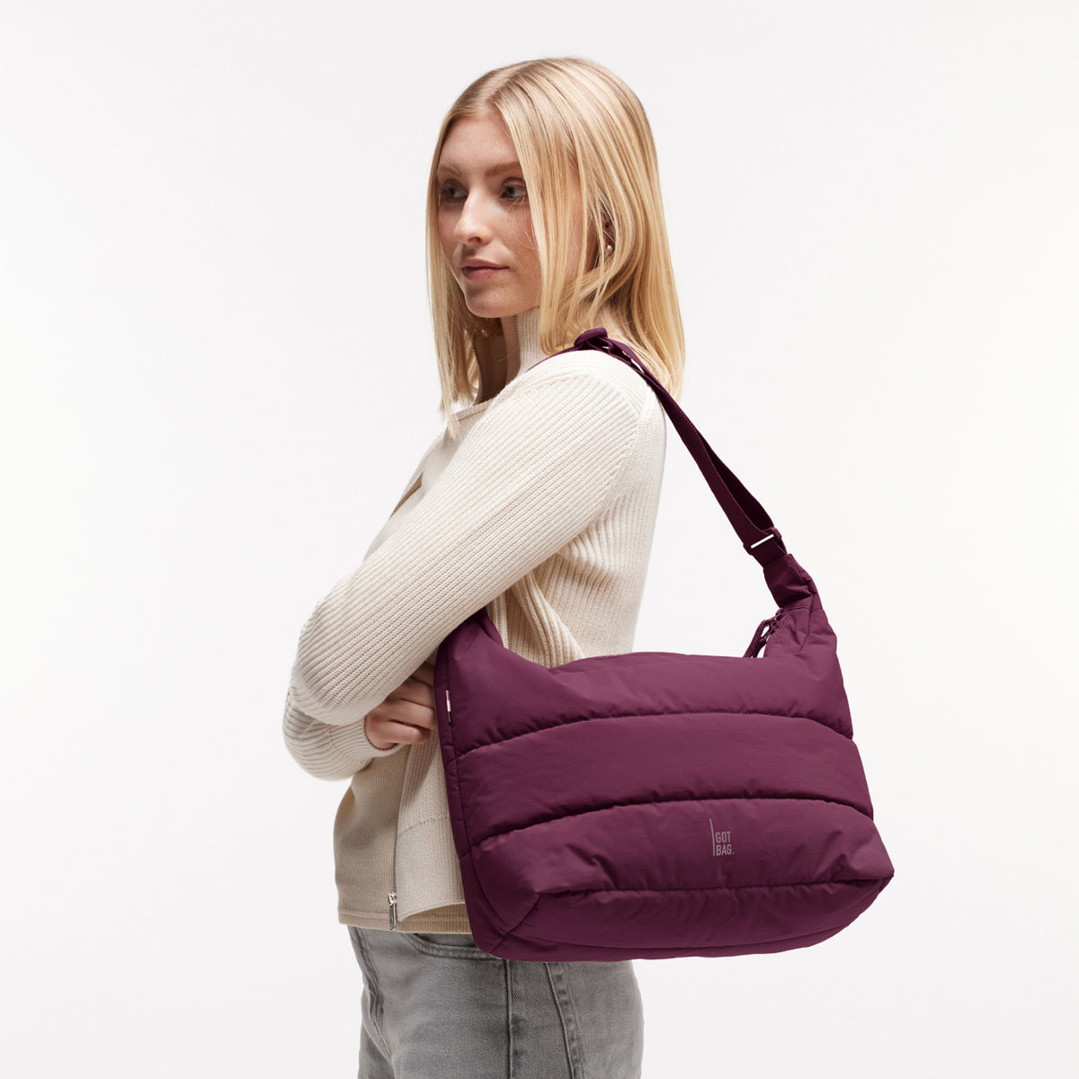 PUFFER SQUARE BAG LARGE Tasche in kraken (Weinrot) von einer Frau über der Schulter getragen.