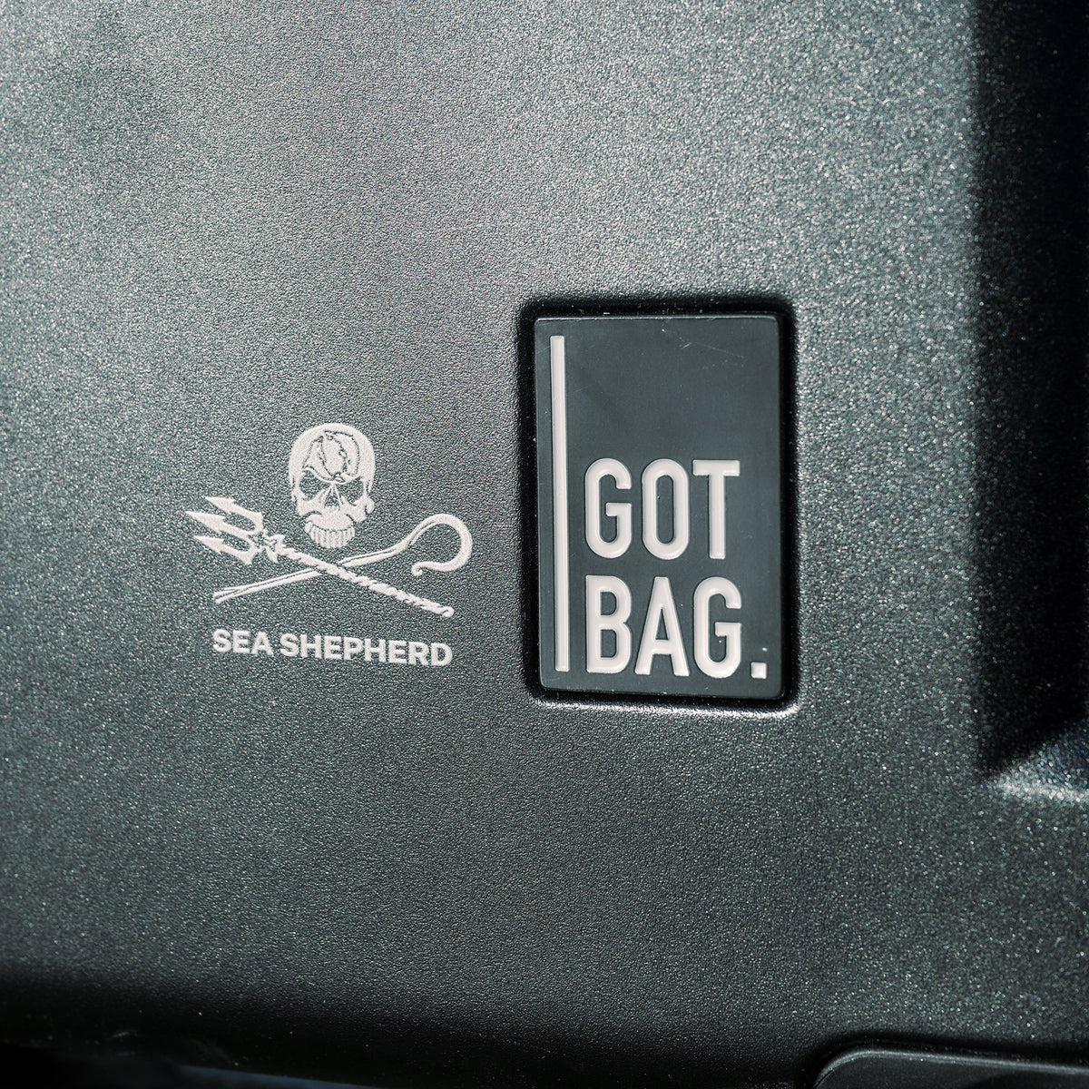 RE SHELL CABIN Koffer in black (Schwarz) mit Sea Shepherd Logo und GOT BAG Schriftzug auf der Oberfläche.