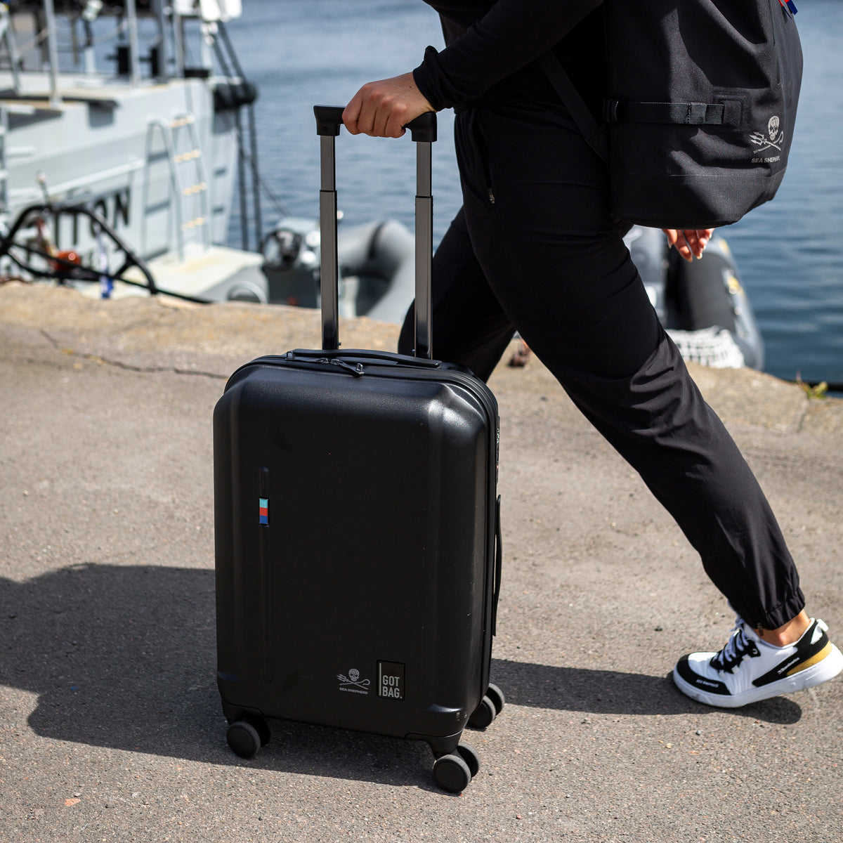 RE-SHELL CABIN Koffer in black (Schwarz) von einem Mann gerollt.