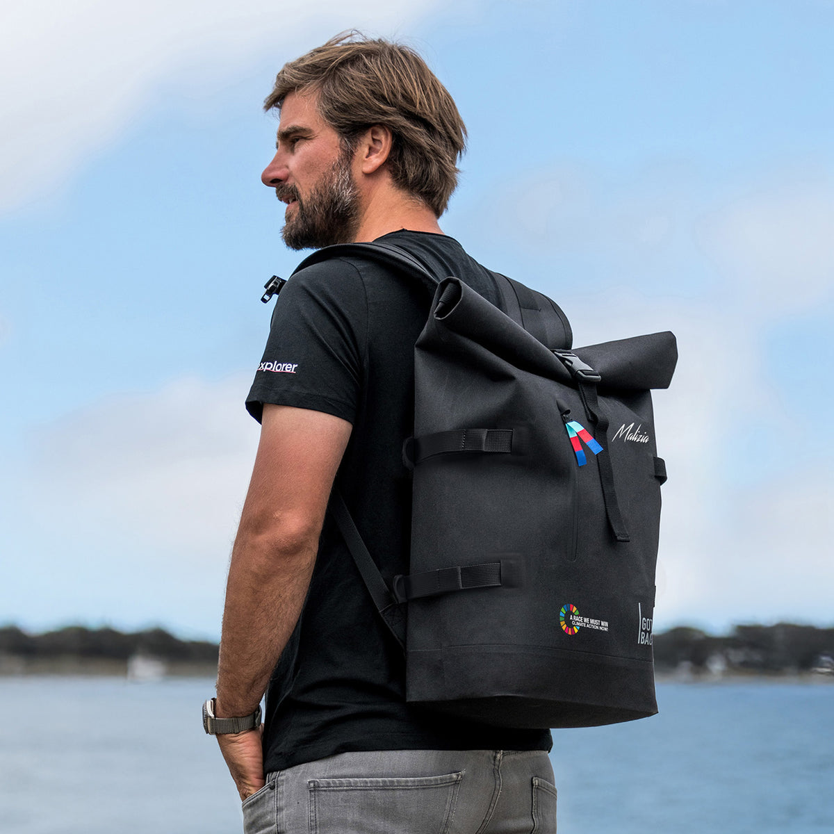 ROLLTOP 2.0 Malizia Rucksack in black (Schwarz) von einem Mann auf dem Rücken getragen.