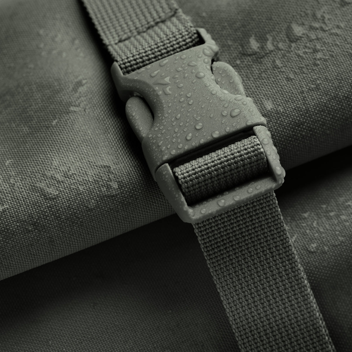 ROLLTOP 2.0 Rucksack in algae (Dunkelgrün mit Graustich), Detailaufnahme mit Wassertropfen auf Verschluss und Stoff.