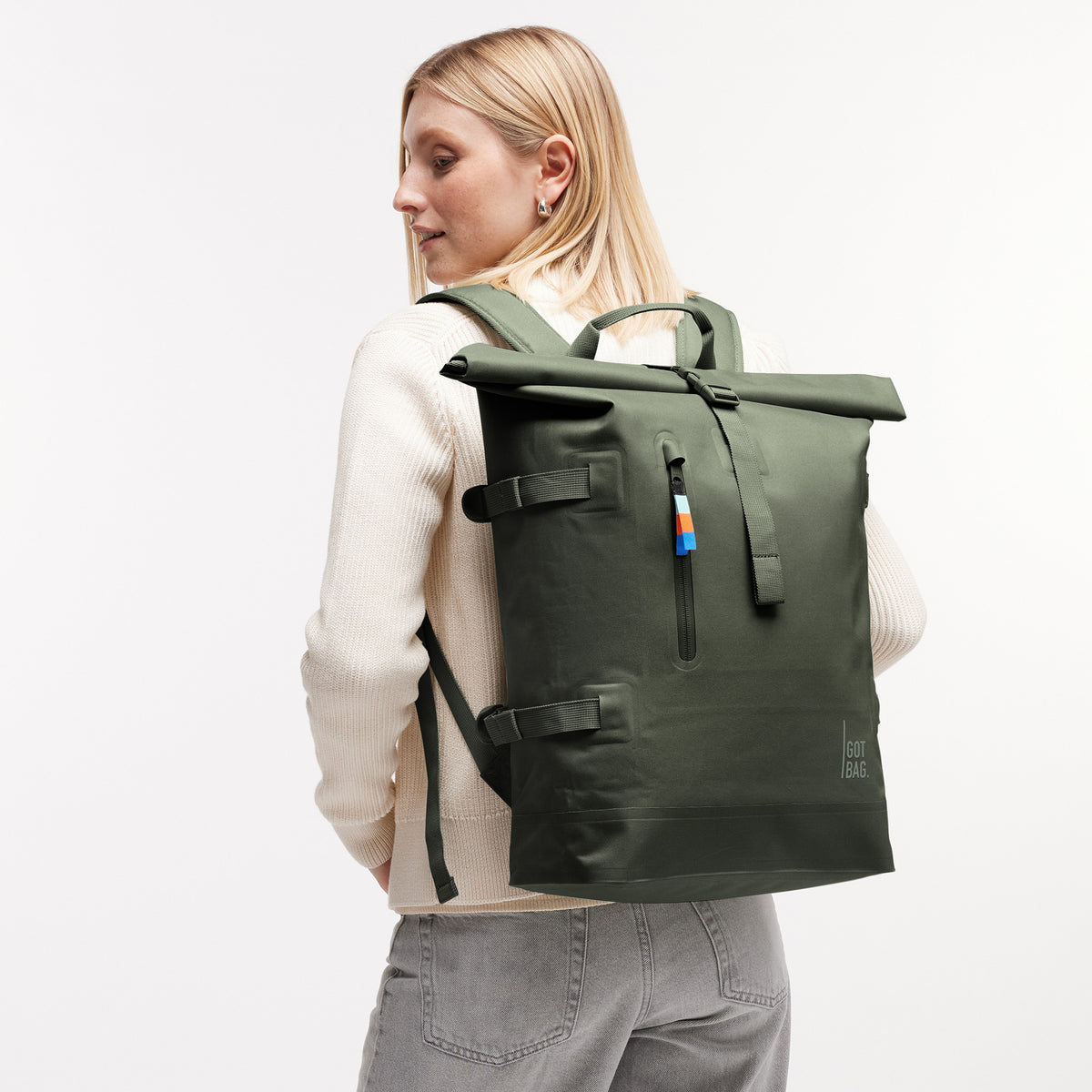 ROLLTOP 2.0 Rucksack in algae (Dunkelgrün mit Graustich) von einer Frau auf dem Rücken getragen.
