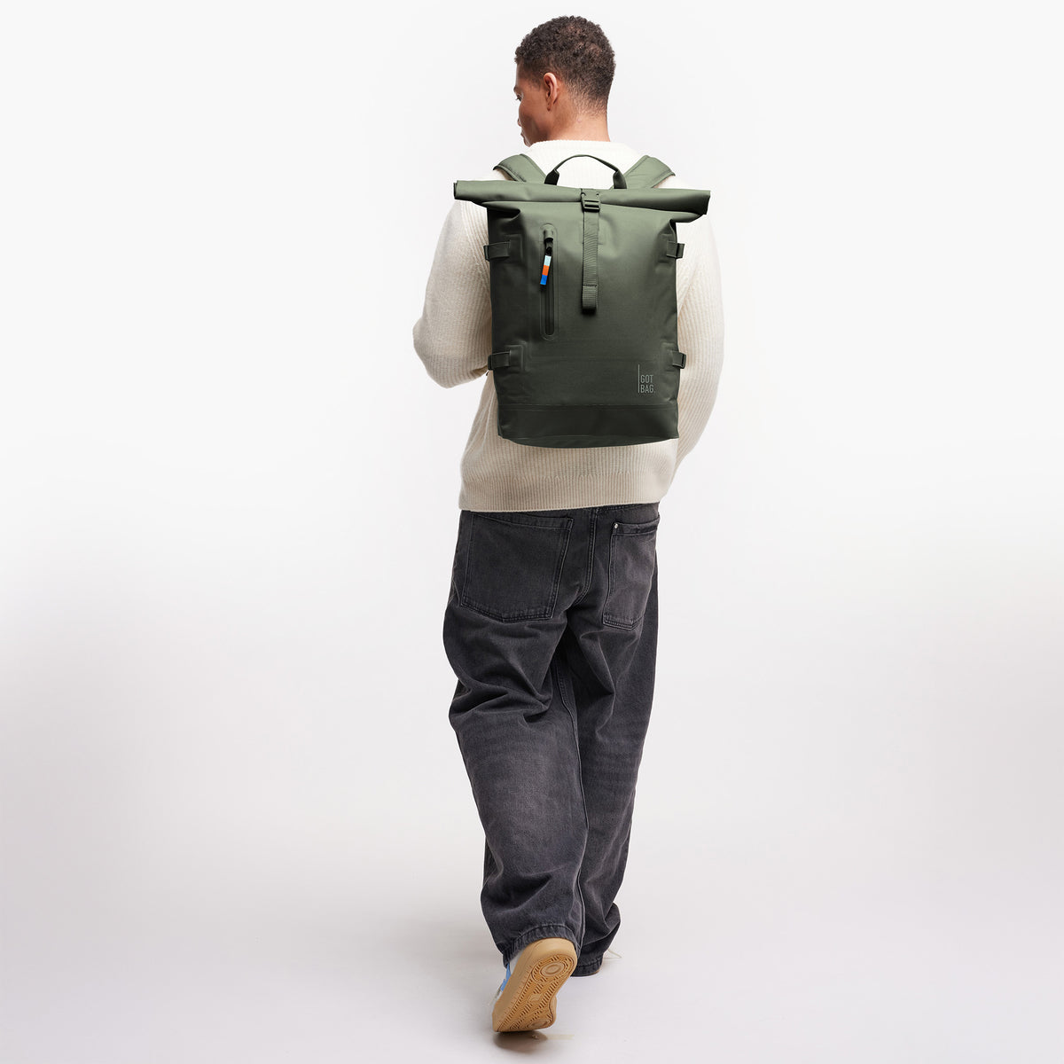 ROLLTOP Rucksack in algae (Dunkelgrün mit Graustich) von einem Mann als Rucksack auf dem Rücken getragen.