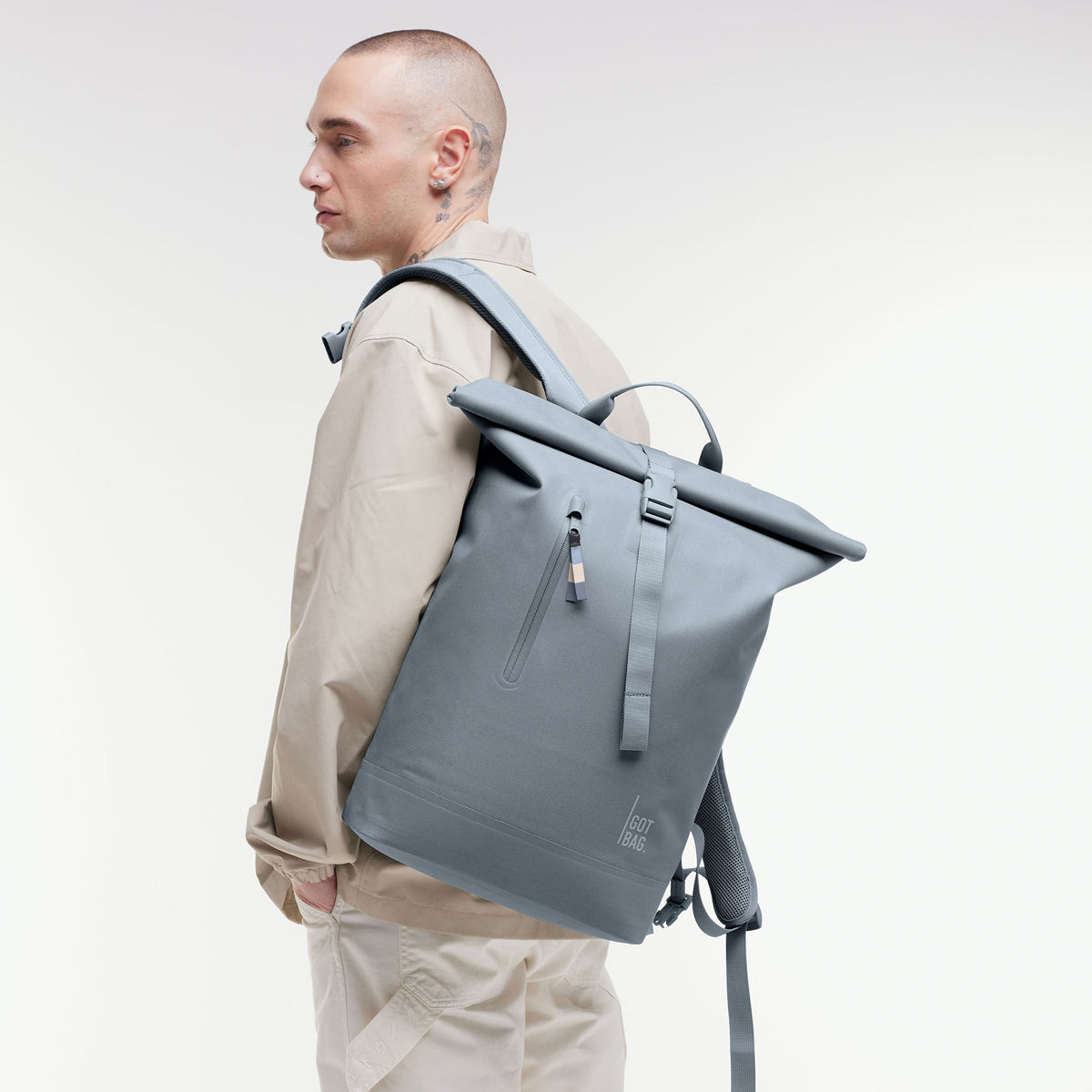 ROLLTOP LITE 2.0 MONOCHROME EDITION Rucksack in marlin (grau-blau) von einem Mann auf dem Rücken getragen.