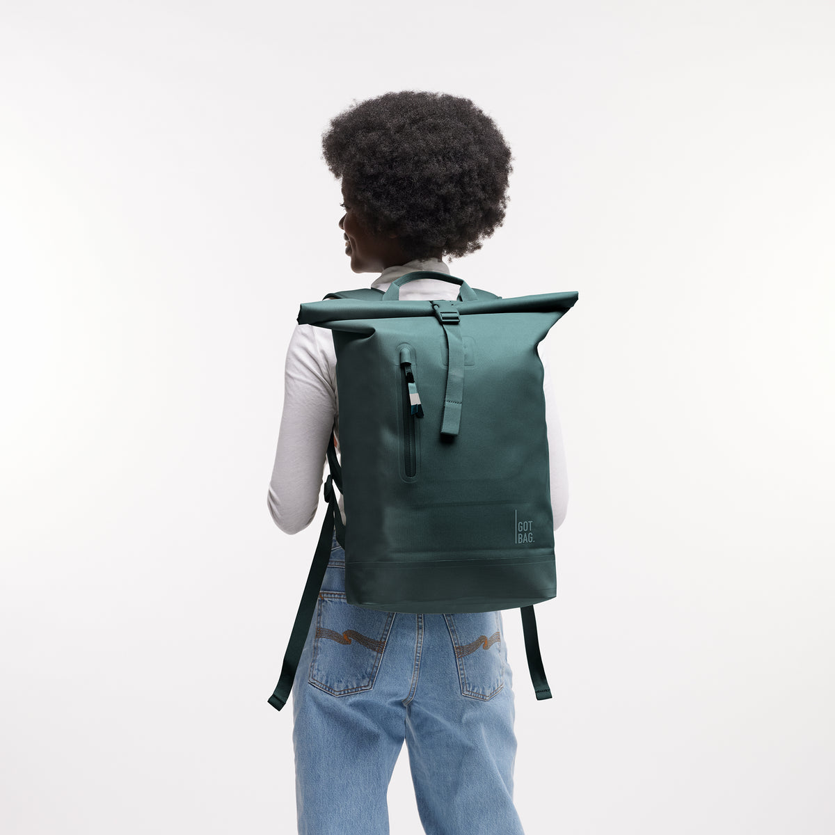 ROLLTOP LITE MONOCHROME EDITION Rucksack in sea teal (kühles Türkisgrün) von einer Frau auf dem Rücken getragen.
