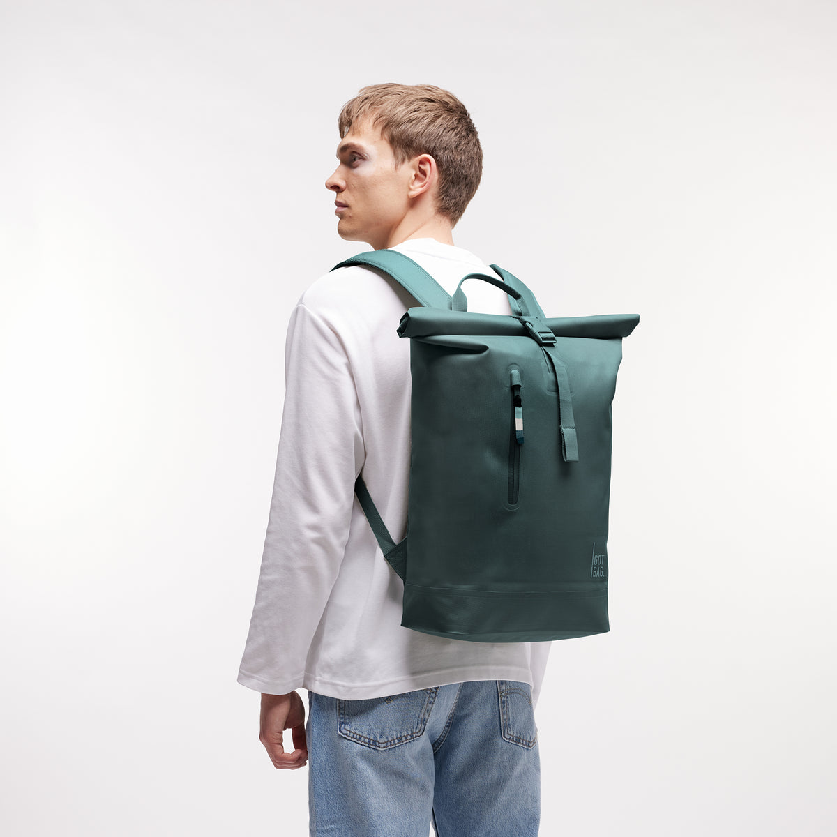 ROLLTOP LITE MONOCHROME EDITION Rucksack in sea teal (kühles Türkisgrün) von einem Mann auf dem Rücken getragen.