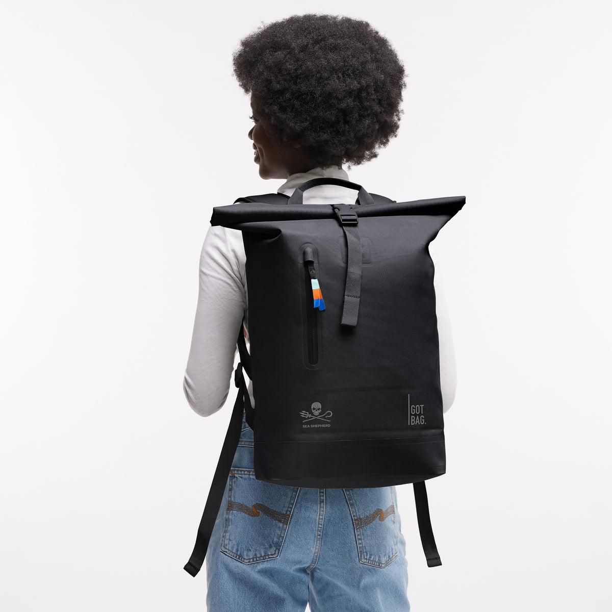 ROLLTOP LITE Rucksack in black (Schwarz) mit Rolltop-Verschluss von einer Frau auf dem Rücken getragen.