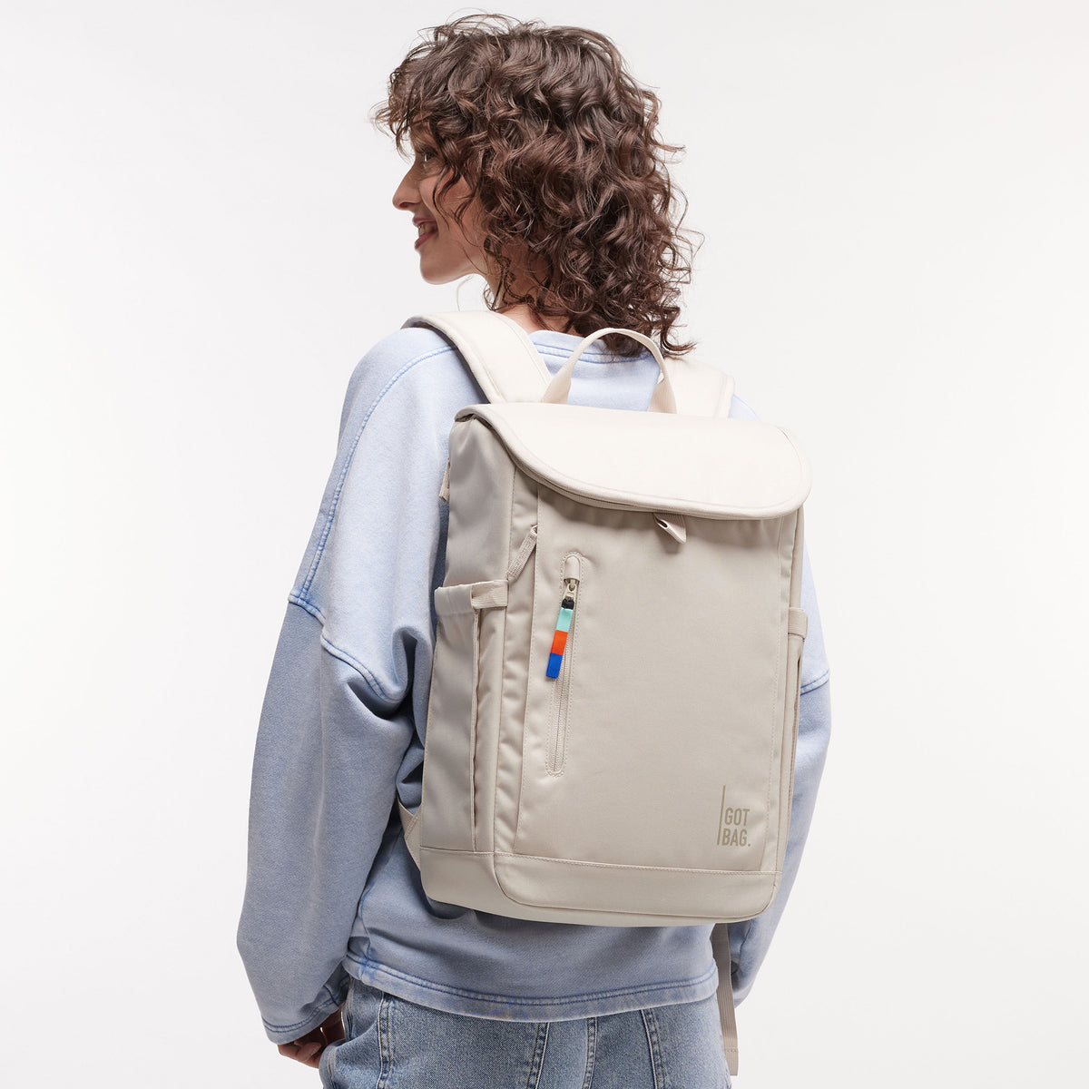 SERENE PACK Rucksack in soft shell (warmes Cremeweiß) von einer Frau als Rucksack auf dem Rücken getragen.