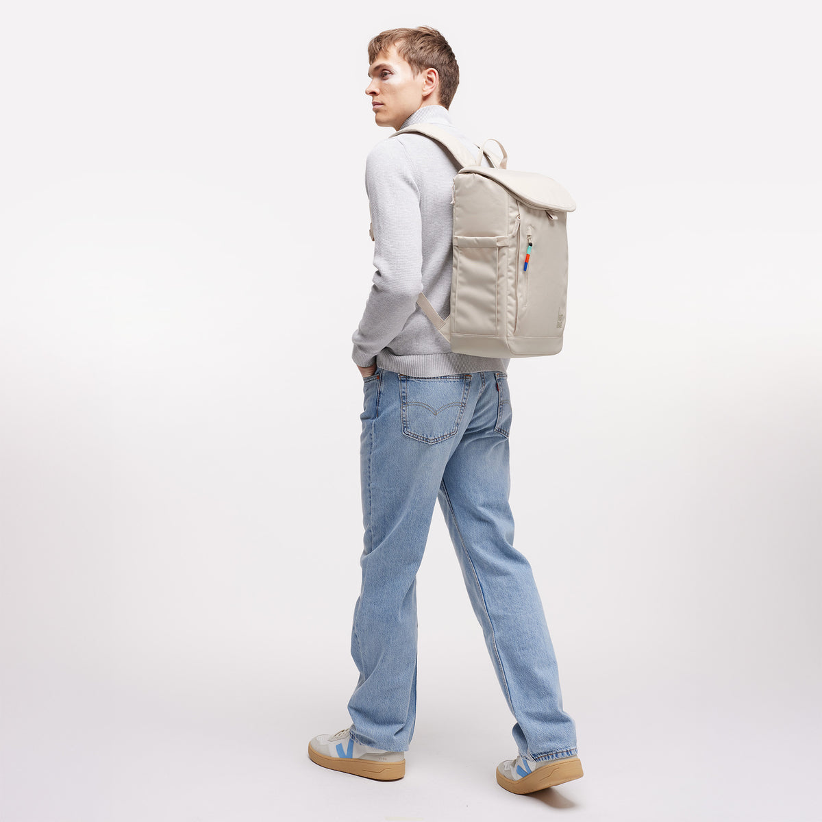 SERENE PACK Rucksack in soft shell (warmes Cremeweiß) von einem Mann auf dem Rücken getragen.
