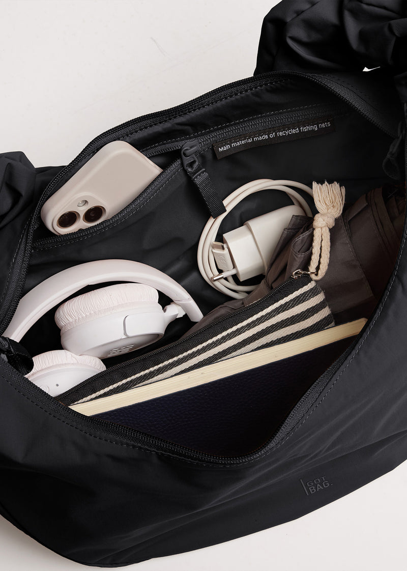 MOON BAG RUFFLE taška v black (Černý). Vnitřní přihrádky, smartphone, sluchátka. Vyrobeno z recyklovaných rybářských sítí.