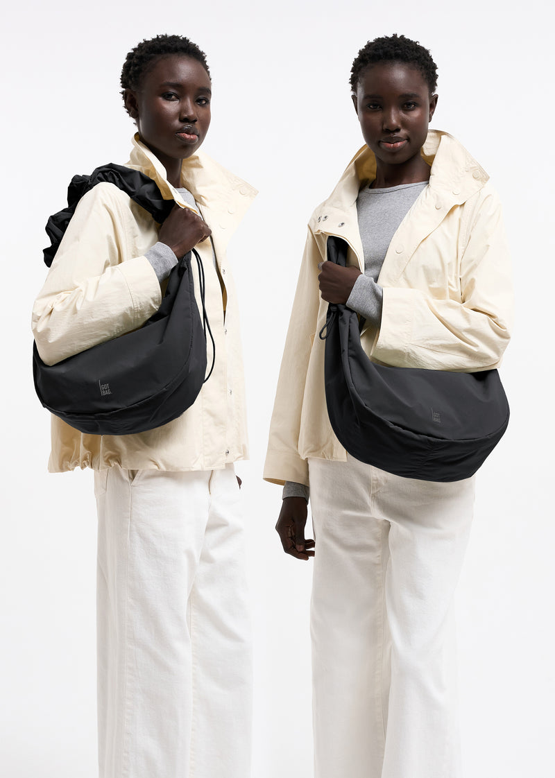 MOON BAG RUFFLE Taška v black (Černý) nošená na paži ženou.