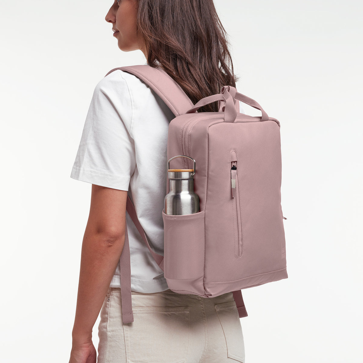 Rucksack von einer Frau auf dem Rücken getragen, mit einer Stahlflasche in der Seitentasche.