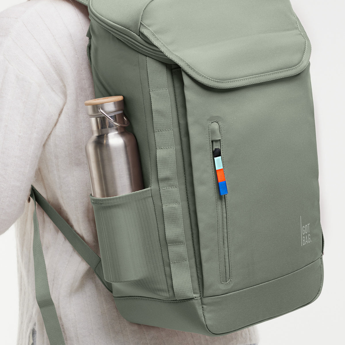 Rucksack auf dem Rücken getragen, mit einer Trinkflasche in der Seitentasche.