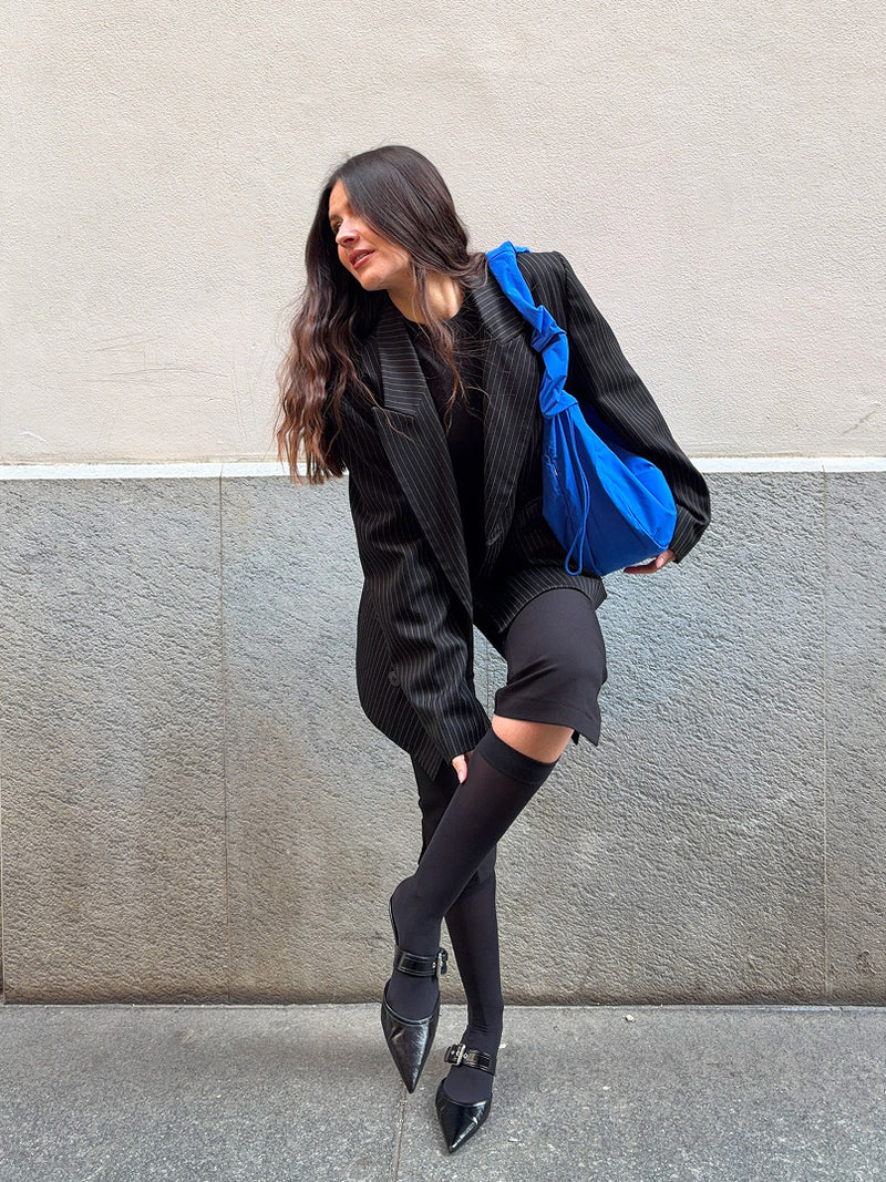 MOON BAG RUFFLE tas in cobalt (Helder kobaltblauw) over de schouder gedragen door een vrouw.