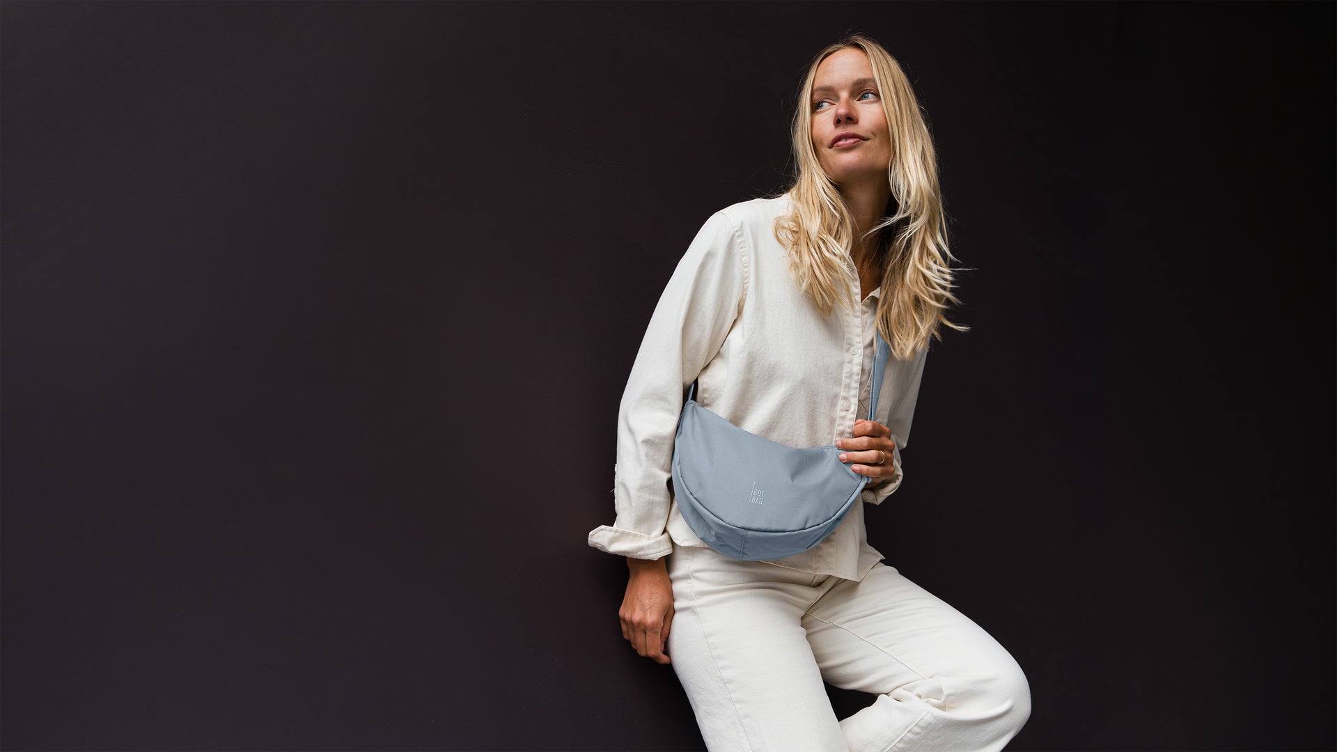MOON BAG SMALL sac en marlin (bleu-gris) porté en bandoulière par une femme.