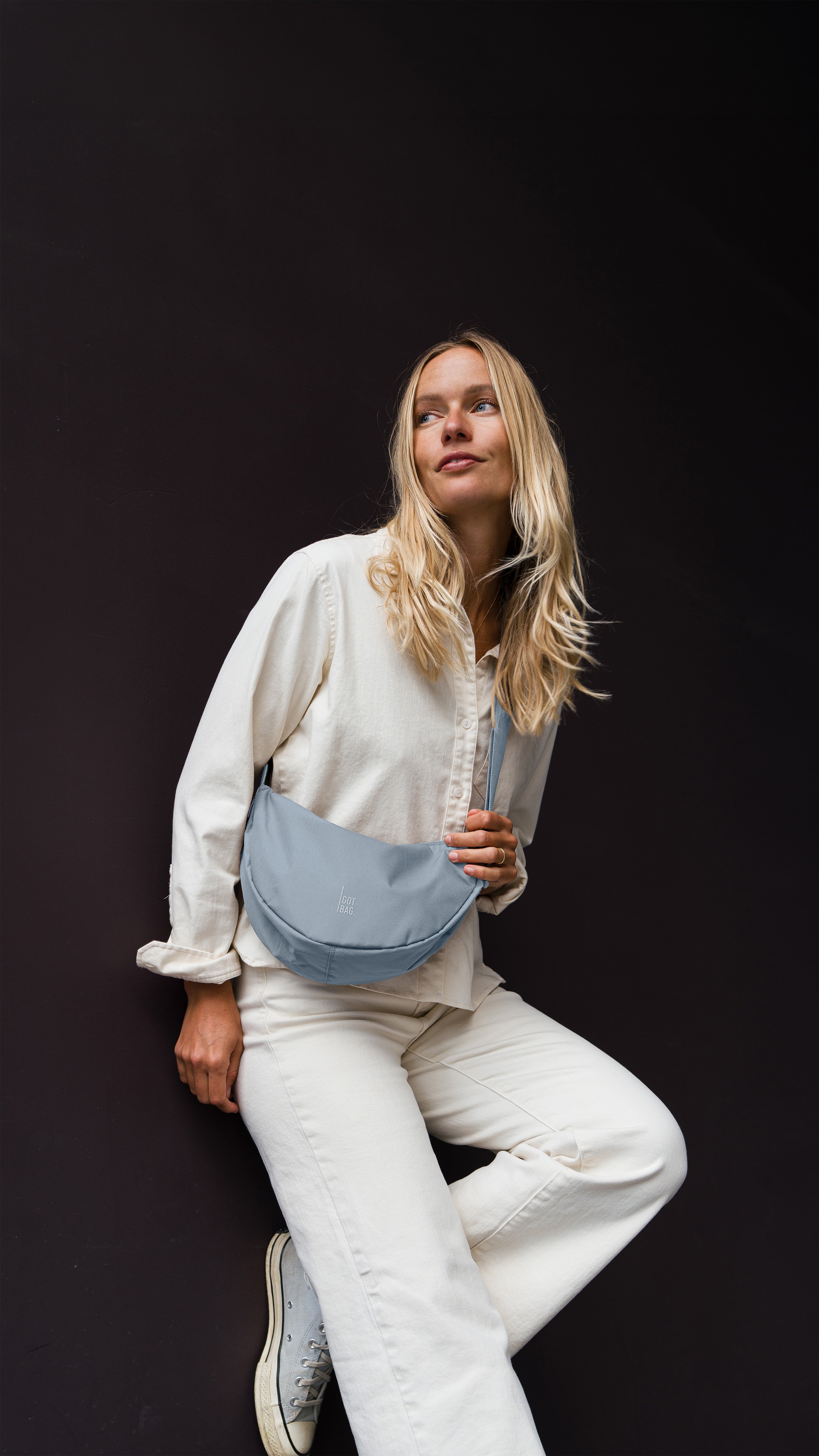 MOON BAG SMALL sac en marlin (bleu-gris) porté en bandoulière par une femme.