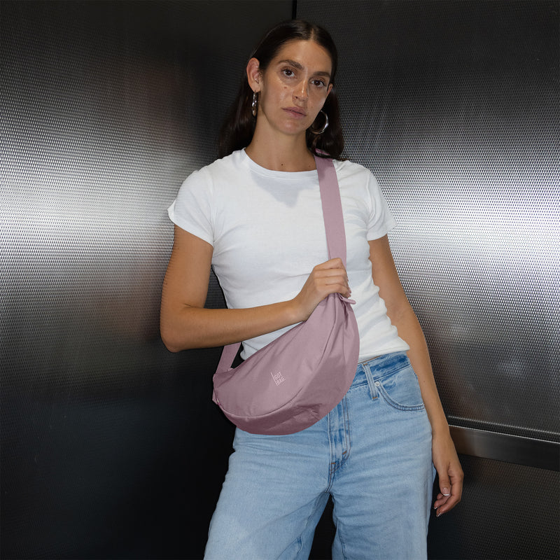 MOON BAG SMALL Tasche in calamary (Altrosa) von einer Frau crossbody getragen.