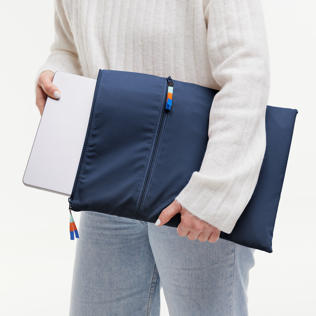 Frau hält ein Laptop-Sleeve Accessoire, in das ein Laptop eingeschoben wird.