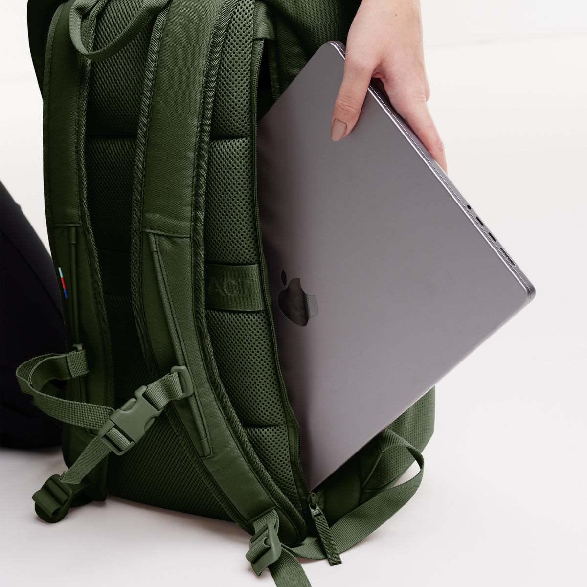 Detailaufnahme eines Rucksacks, in dessen Laptop-Fach eine Frau einen Laptop steckt.