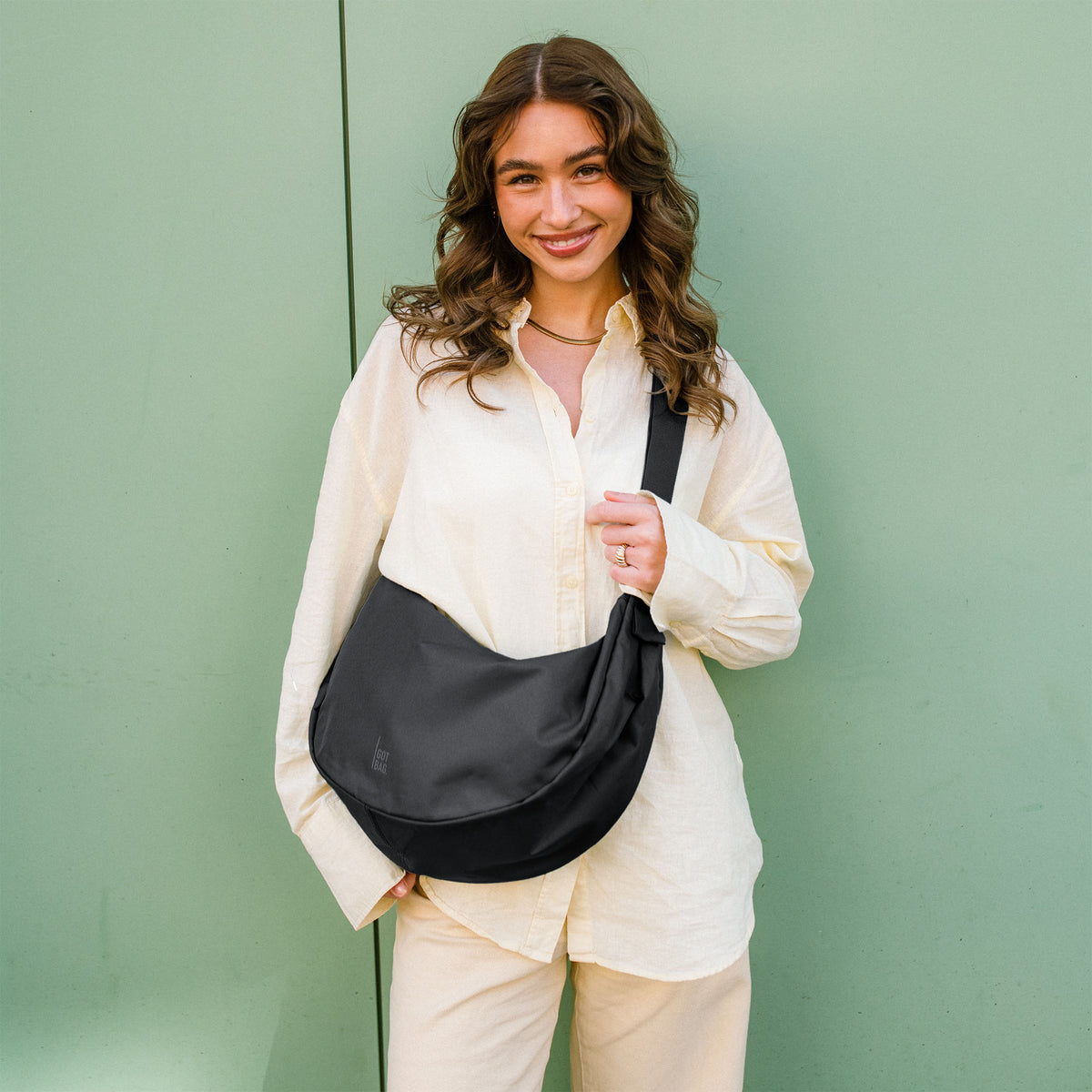 MOON BAG LARGE Tasche in black (Schwarz) von einer Frau crossbody getragen.