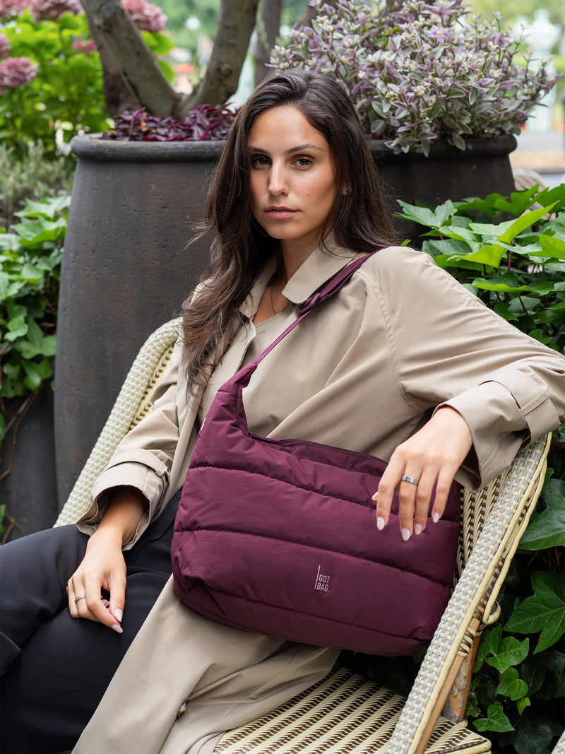 PUFFER SQUARE BAG tas in kraken (Wijnrood) crossbody gedragen door een vrouw.